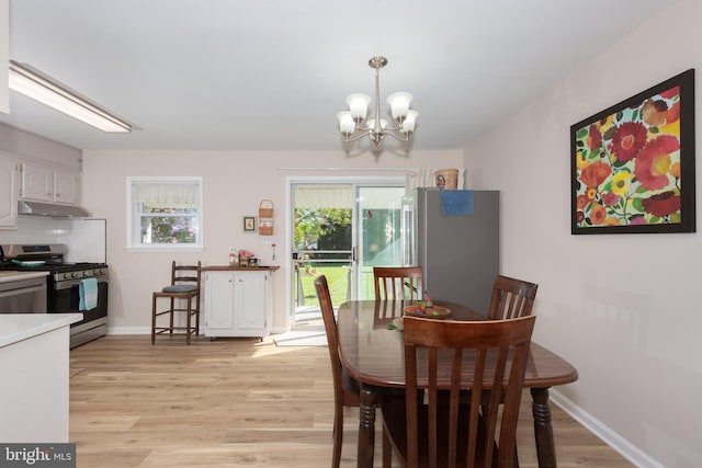 dining space featuring an inviting chandelier, baseboards, and light wood-style floors
