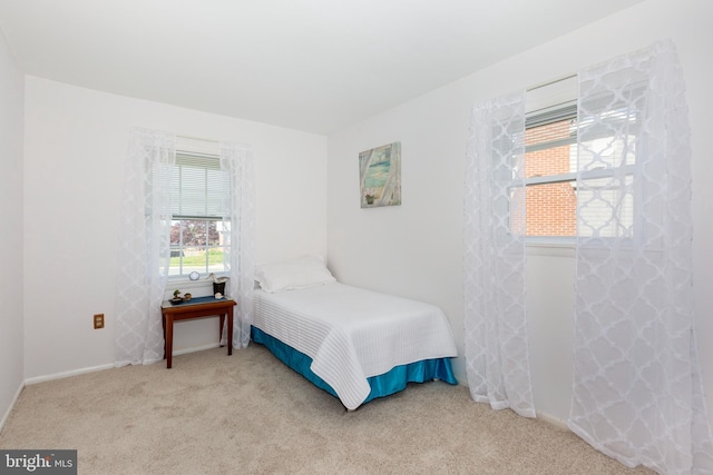 bedroom with baseboards and carpet