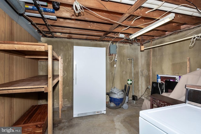 unfinished below grade area with washer / dryer and freestanding refrigerator