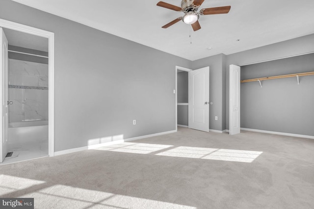 unfurnished bedroom with light carpet, connected bathroom, a closet, and ceiling fan