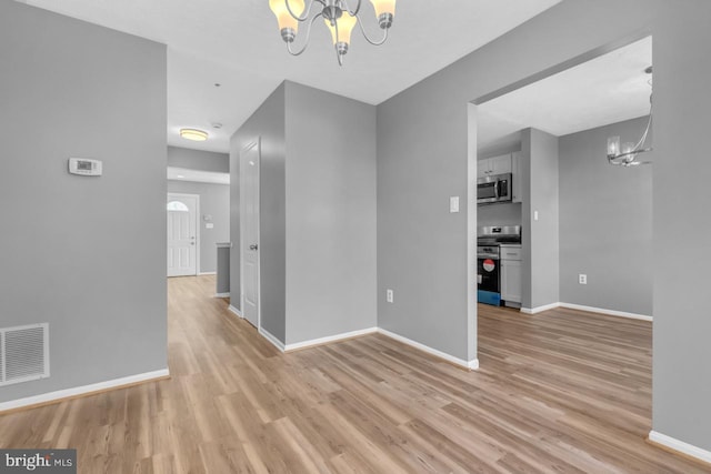 unfurnished dining area with light wood-type flooring and a notable chandelier