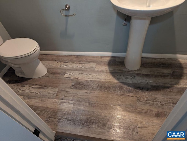 bathroom with hardwood / wood-style floors and toilet