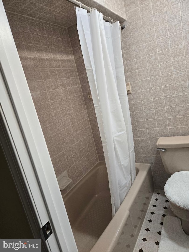 bathroom with toilet and shower / bath combo with shower curtain