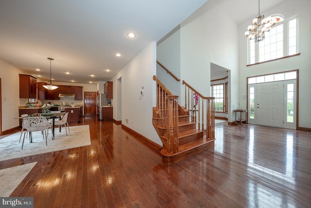 entrance foyer featuring dark hardwood / wood-style flooring, a chandelier, and a high ceiling