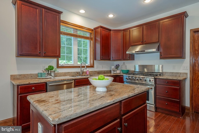 kitchen featuring sink, appliances with stainless steel finishes, light stone counters, a kitchen island, and dark hardwood / wood-style flooring