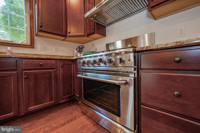 kitchen featuring dark hardwood / wood-style flooring, high end stainless steel range, light stone counters, and wall chimney exhaust hood