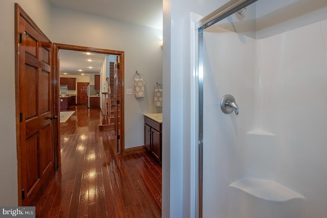 bathroom with hardwood / wood-style flooring, vanity, and an enclosed shower