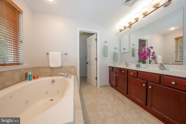 bathroom with vanity, tiled tub, and tile patterned flooring