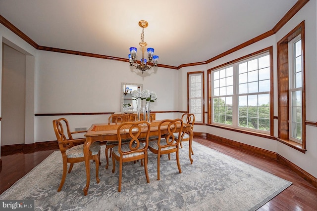 dining room featuring ornamental molding, hardwood / wood-style floors, and a notable chandelier