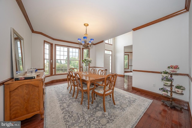 dining space featuring crown molding, dark wood-type flooring, and a chandelier