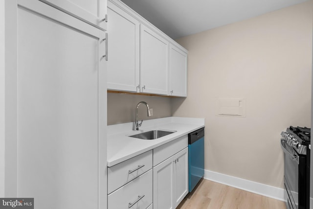 kitchen with light hardwood / wood-style floors, white cabinetry, sink, and appliances with stainless steel finishes