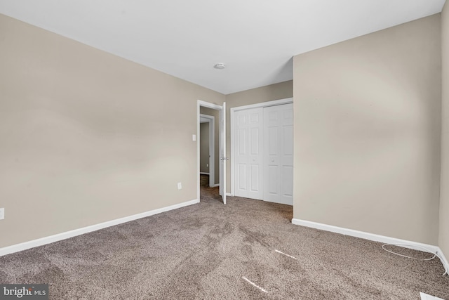 unfurnished bedroom featuring carpet flooring and a closet