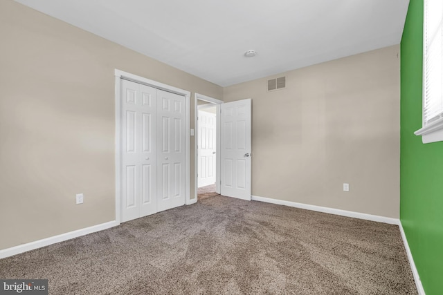 unfurnished bedroom featuring carpet floors and a closet