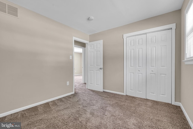 unfurnished bedroom with carpet flooring and a closet