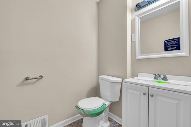 bathroom with tile patterned flooring, vanity, and toilet