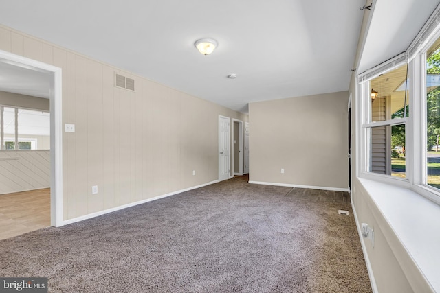 carpeted spare room featuring plenty of natural light