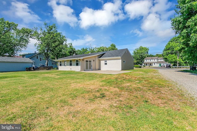 back of house featuring a lawn and a patio