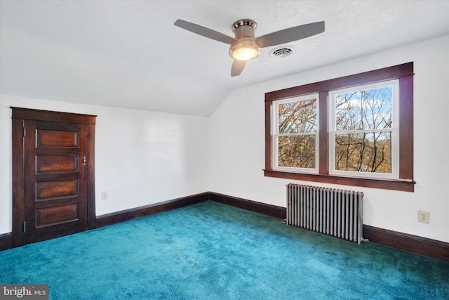 bonus room featuring ceiling fan, radiator heating unit, lofted ceiling, and dark colored carpet