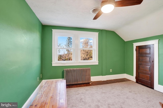 bonus room featuring radiator, ceiling fan, wood-type flooring, and lofted ceiling