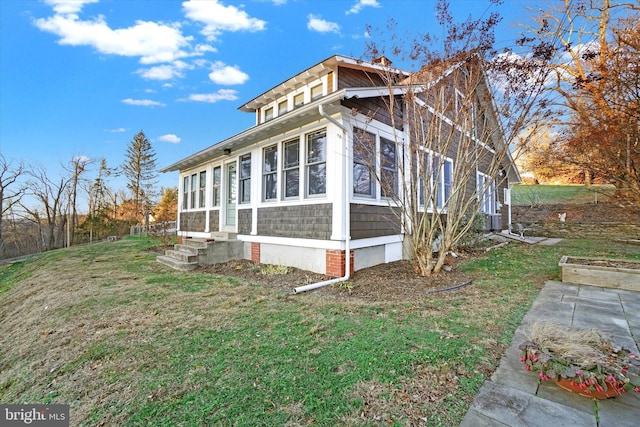 view of home's exterior featuring cooling unit and a yard