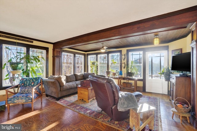 living room featuring beam ceiling, ceiling fan, wood-type flooring, and ornamental molding