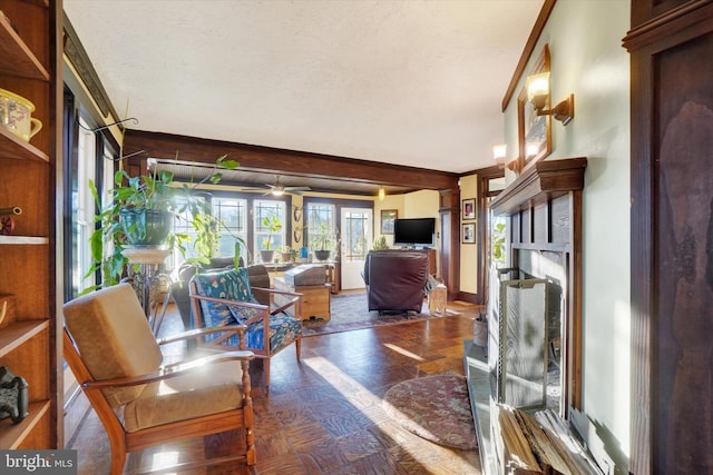 interior space with parquet floors, a textured ceiling, ceiling fan, crown molding, and beamed ceiling