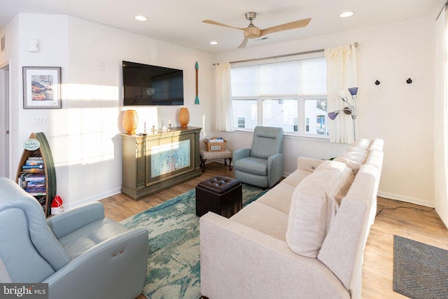 living room with light wood-type flooring and ceiling fan