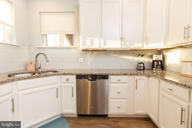 kitchen featuring light stone countertops, sink, white cabinets, and stainless steel dishwasher