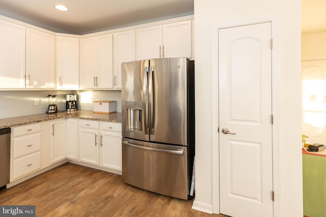 kitchen featuring light stone counters, white cabinetry, stainless steel appliances, and light hardwood / wood-style flooring