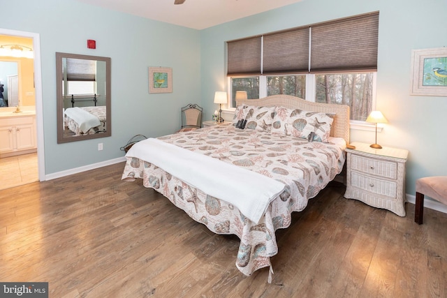 bedroom with ensuite bathroom and dark hardwood / wood-style flooring