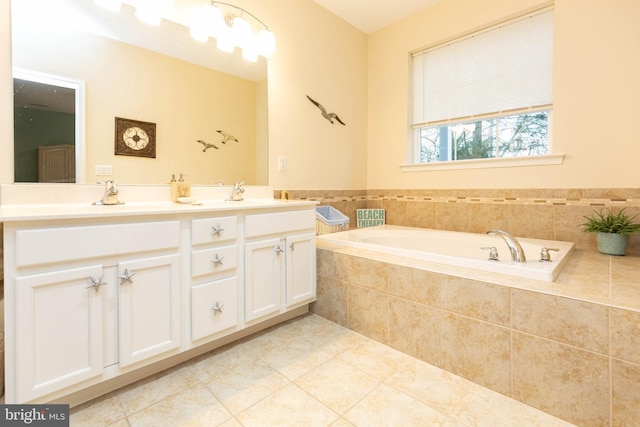 bathroom featuring tile patterned flooring, a relaxing tiled tub, and vanity