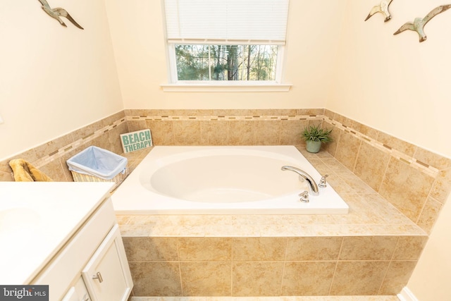 bathroom featuring vanity and tiled tub