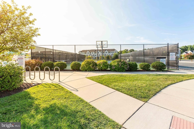 view of home's community with a lawn and basketball hoop