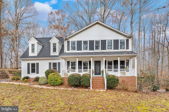 view of front of house with covered porch and a front lawn