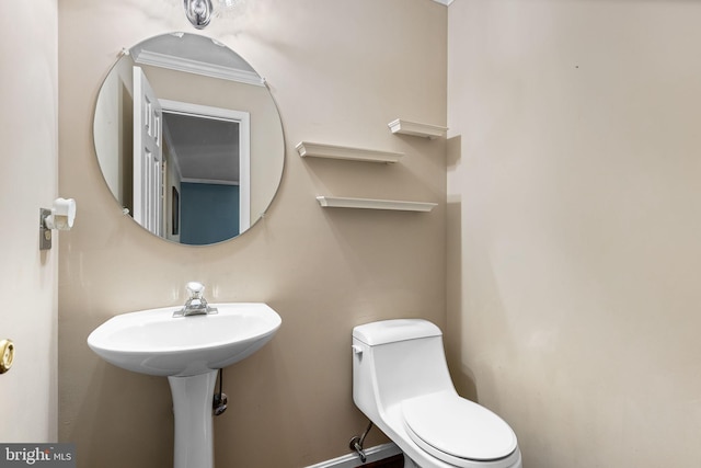 bathroom featuring crown molding and toilet