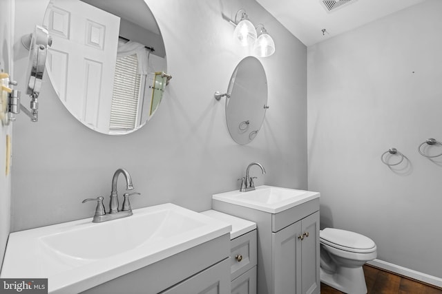 bathroom featuring vanity, toilet, and wood-type flooring