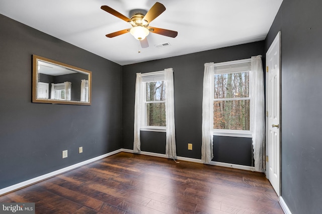 empty room featuring ceiling fan and dark wood-type flooring