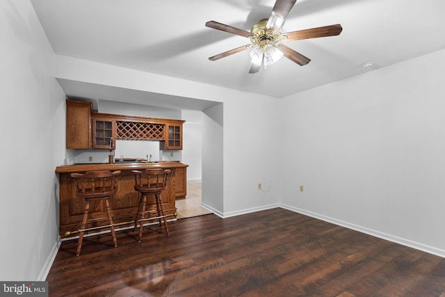 bar with dark hardwood / wood-style flooring, white fridge, and ceiling fan