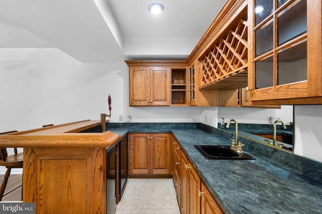 kitchen featuring kitchen peninsula, light tile patterned floors, dark stone countertops, and sink