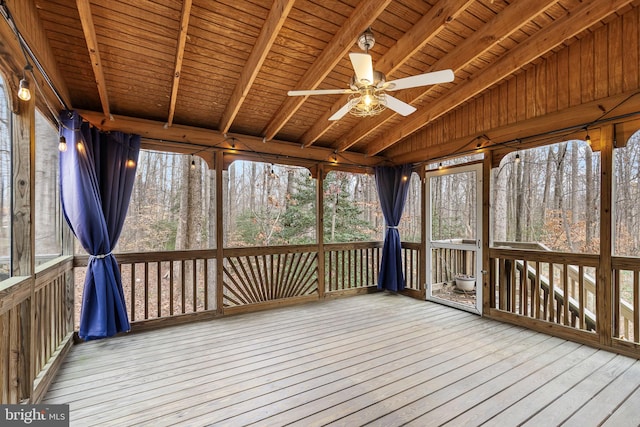 unfurnished sunroom with vaulted ceiling with beams, a wealth of natural light, ceiling fan, and wooden ceiling