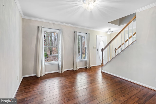 entrance foyer featuring dark hardwood / wood-style flooring, crown molding, and a chandelier