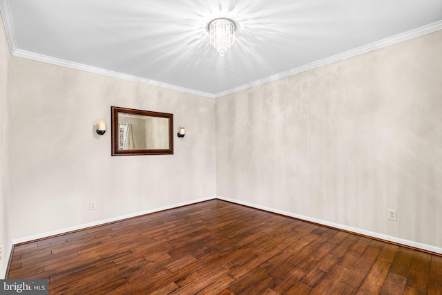 empty room featuring hardwood / wood-style flooring, an inviting chandelier, and ornamental molding