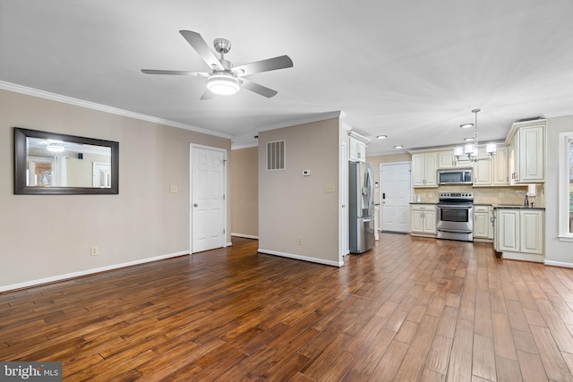 unfurnished living room featuring hardwood / wood-style floors, ceiling fan with notable chandelier, sink, and crown molding