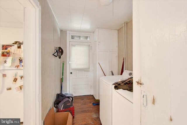 clothes washing area featuring dark wood-type flooring and washing machine and clothes dryer