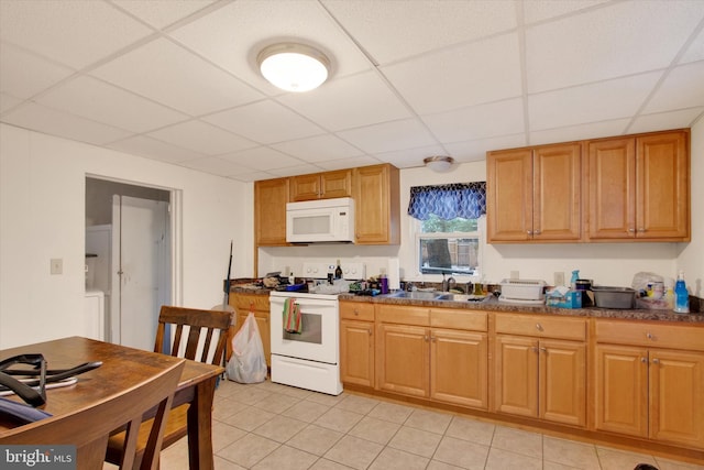 kitchen with a drop ceiling, white appliances, and sink