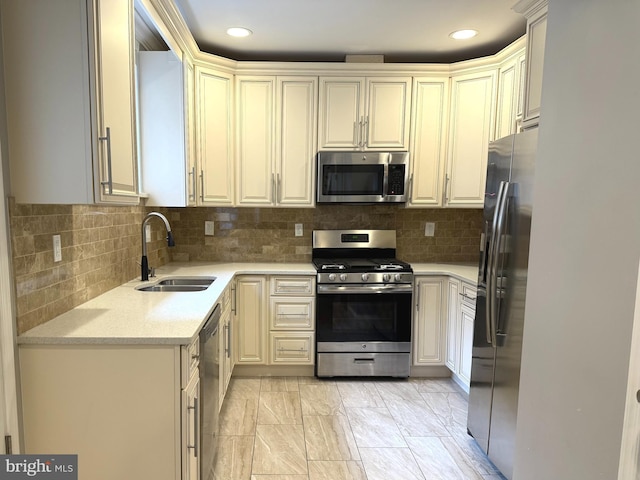 kitchen with cream cabinets, decorative backsplash, sink, and stainless steel appliances