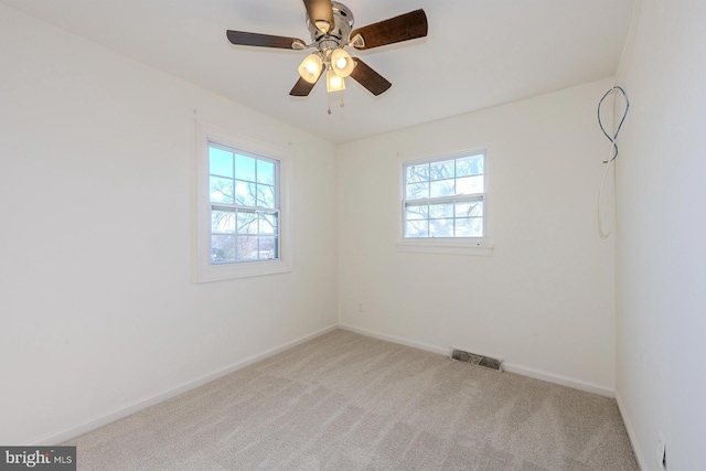 empty room featuring light colored carpet and ceiling fan