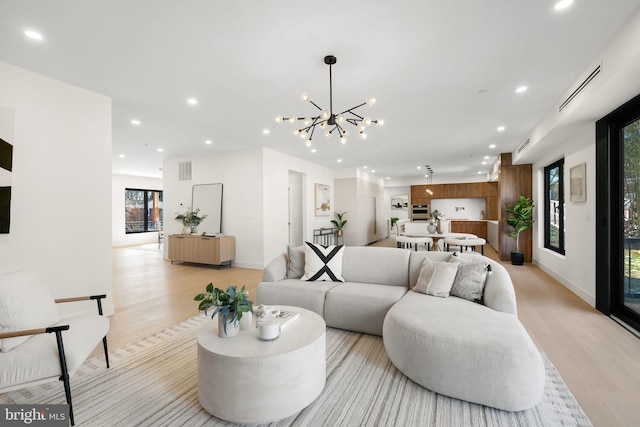 living room with light hardwood / wood-style flooring and a chandelier