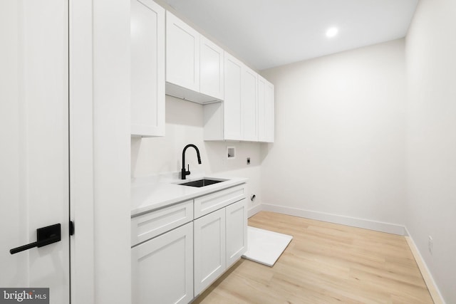 washroom featuring washer hookup, sink, light hardwood / wood-style floors, cabinets, and electric dryer hookup