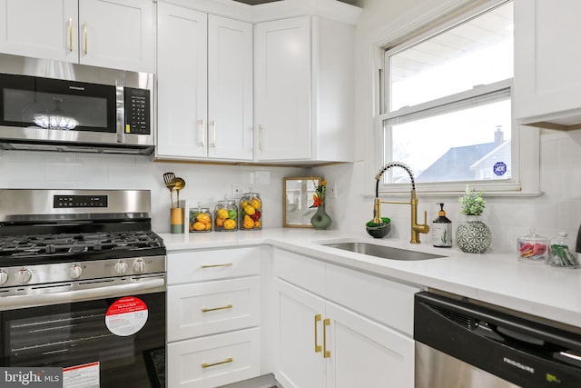 kitchen with white cabinets, decorative backsplash, sink, and stainless steel appliances